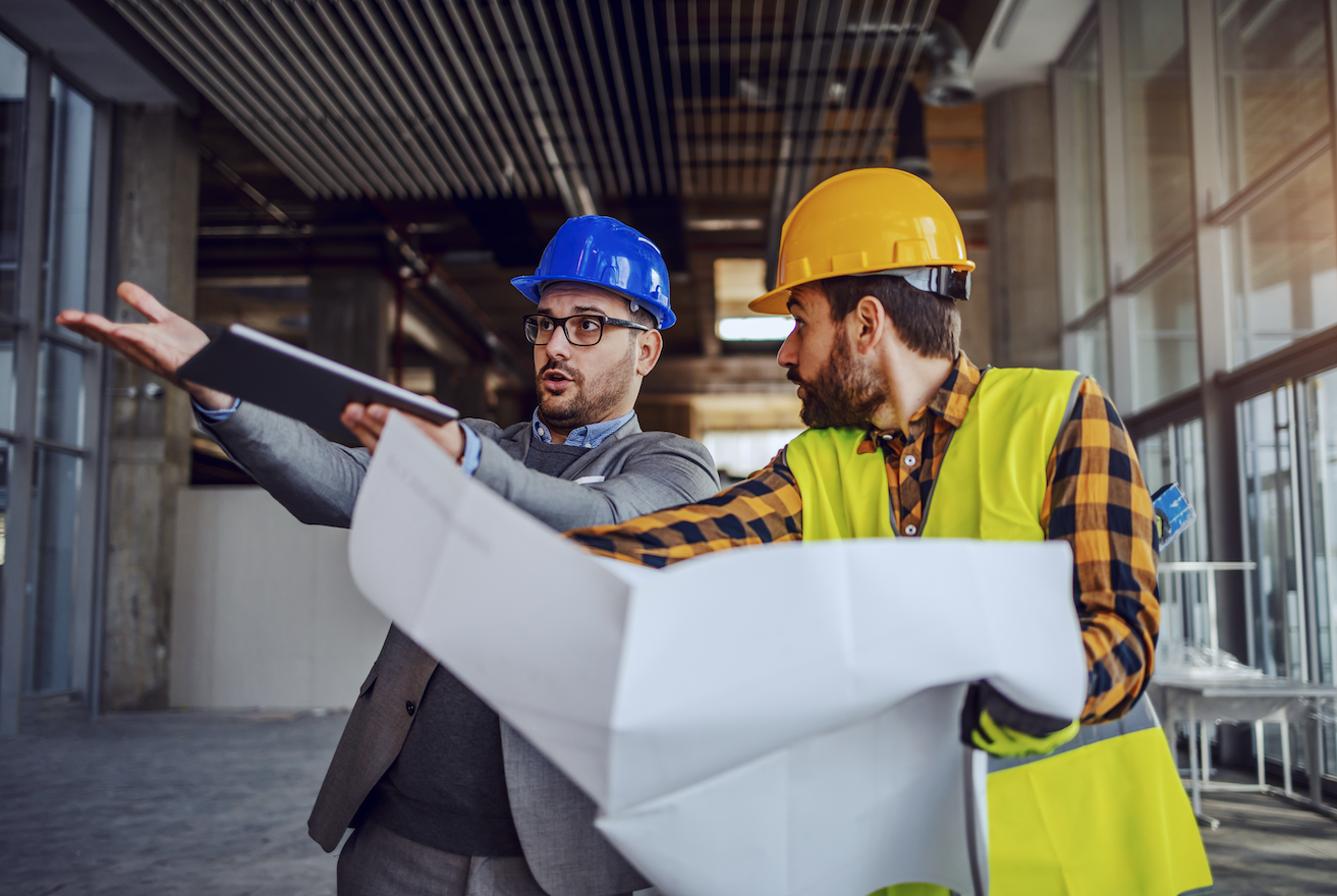Architect and construction worker arguing on site